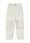 Helle beige Hosen mit einer glatten Textur, die an den unteren Vorderpaneelen silberne Nieten aufweisen. Enthält Fronttaschen und einen Knopfverschluss.