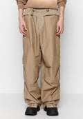 Beige, lockere Hose aus einem strukturierten, leichten Material. Verfügt über einen verstellbaren Bund und fransige Details an den Taschen.
