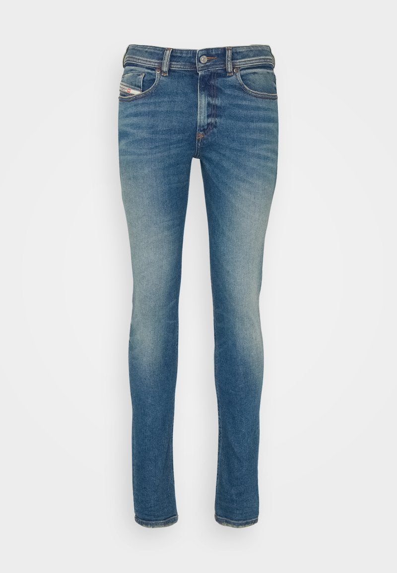 Schlank geschnittene Denim-Jeans in mittlerer blauer Waschung, mit subtilen Abnutzungsstellen, fünf Taschen und einem Kontrastnähdetail entlang der Nähte.