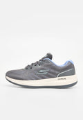 Grauer Sportschuh mit oberem Mesh, hellblauen Akzenten, dicker weißer Mittelsohle und schwarzem outsole. Verfügt über ein Logo an der Seite und der Ferse.