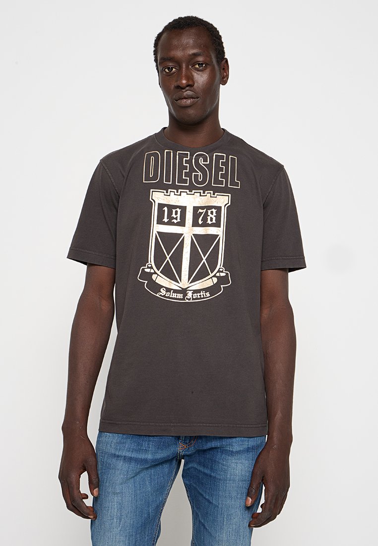 Graues kurzärmeliges T-Shirt mit "DIESEL"-Logo in fetter weißer Schrift und einer Schildgrafik, die die Zahlen "1978" und den Text "Solum Fortis" zeigt.