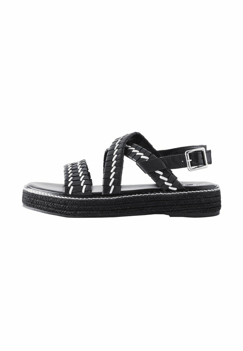 Schwarze geflochtene Ledersandalen mit einem verstellbaren Knöchelriemen, kontrastierenden weißen Nähten und einer robusten strukturierten Sohle.
