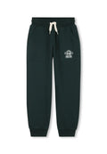 Grüne Sweatpants aus weichem Material, mit zwei Seitentaschen, einem elastischen Bund mit Kordelzug und einem weißen Logo auf dem linken Oberschenkel.