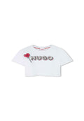 Weißes, kurzes T-Shirt mit dem Aufdruck "HUGO" in fetten Buchstaben, begleitet von einer roten Lutschersgrafik. Kurze Ärmel und runder Halsausschnitt. Glatte Textur.