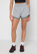 Graue Sportshorts mit elastischem Bund, mehrlagigem Design und kontrastierendem Innenfutter, kombiniert mit dunkelroten Sportschuhen.