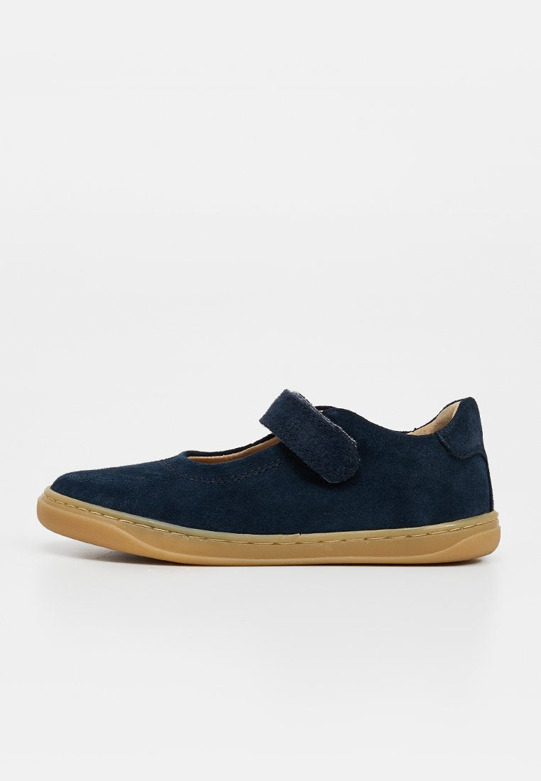Marineblauer Wildleder-Mary-Jane-Schuh mit beige-gummierter Sohle und verstellbarem Klettverschluss, von der Seite auf weißem Hintergrund gezeigt.