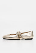 Goldfarbener, metallischer flacher Schuh mit dekorativem Perlen- und Perlenriemen mit goldener Schnallendetail auf weißem Hintergrund.