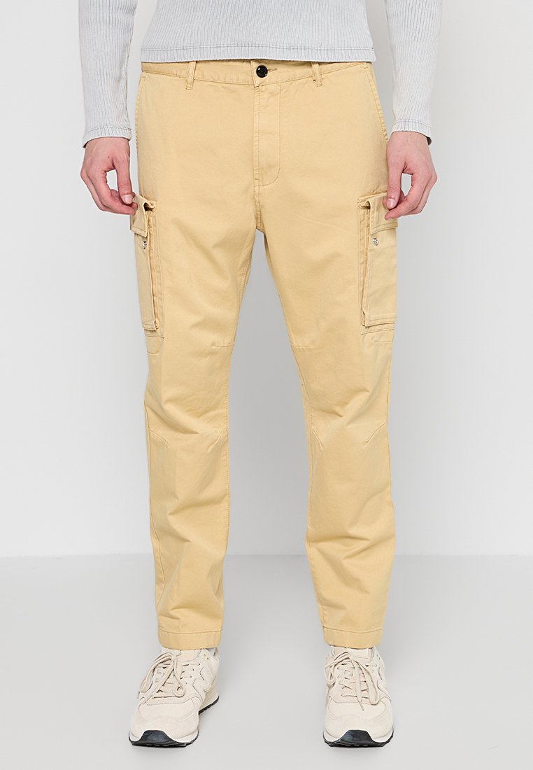 Beige Cargo-Hosen aus leichtem Stoff, mit zwei seitlichen Taschen, einer normalen Passform und einem Knopfverschluss an der Taille.