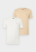 Zwei schlichte T-Shirts mit Rundhalsausschnitt, eines weiß und eines beige, jeweils mit kleinem Tommy Hilfiger-Logo auf der linken Brust.
