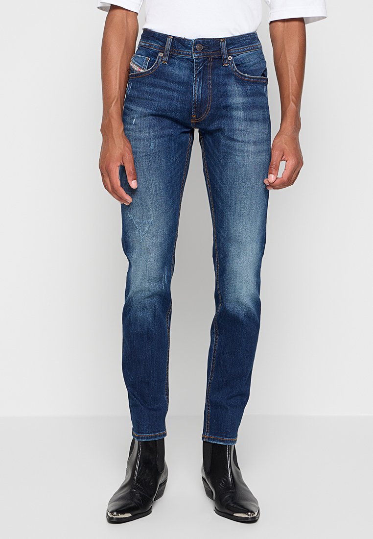 Dunkelblaue Denim-Jeans im Slim-Fit, mit subtilen Ausbleichungen, geraden Beinen, Knopfverschluss und dekorativem Stickerei an den Taschen.