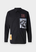 Schwarzes Langarmshirt aus Baumwolle. Verfügt über mehrere Stoffpatches mit Grafiken, darunter ein Schädel und abstrakte Designs.