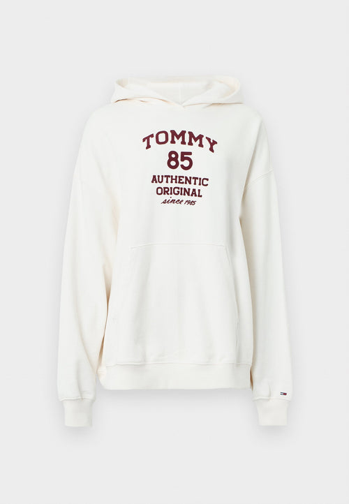 Cremefarbener Hoodie mit einer Fronttasche, Kordelzug am Kapuzenrand und weinrotem Text mit der Aufschrift "TOMMY 85 AUTHENTIC ORIGINAL since 1985."