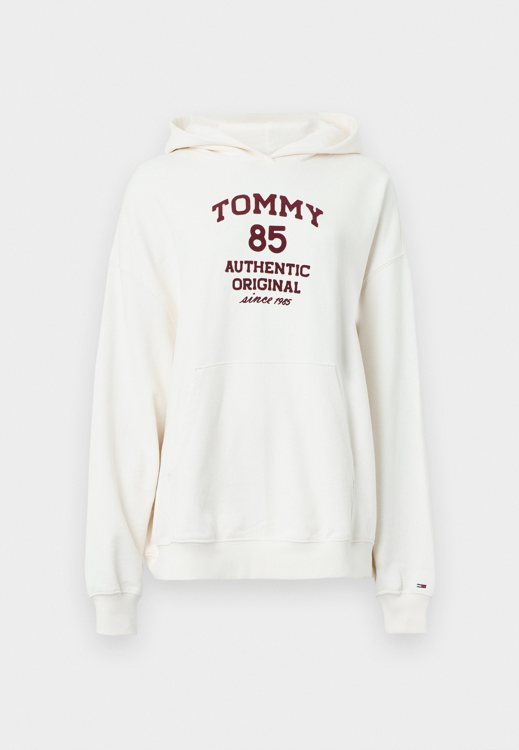 Cremefarbener Hoodie mit einer Fronttasche, Kordelzug am Kapuzenrand und weinrotem Text mit der Aufschrift "TOMMY 85 AUTHENTIC ORIGINAL since 1985."