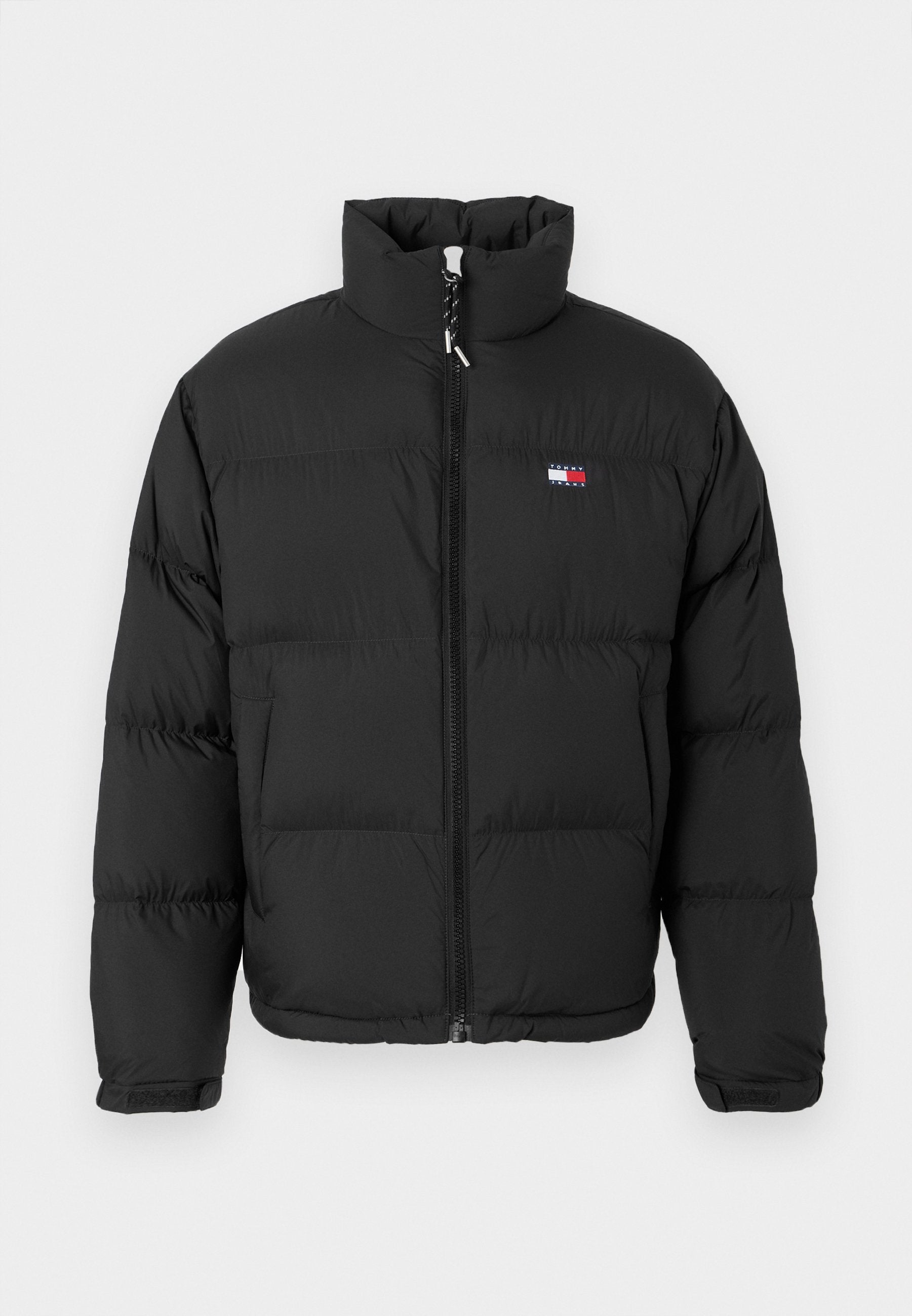 Schwarze Daunenjacke mit hohem Kragen, durchgehendem Reißverschluss und horizontalen Nähten. Mit einem kleinen Logopatch auf der linken Brust.