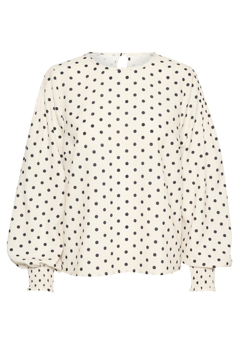Cremfarbene Bluse mit schwarzen Punkten, runder Ausschnitt, Schlüsselverschluss hinten und Puffärmeln mit gerafften Manschetten. Weicher Baumwollmischstoff.