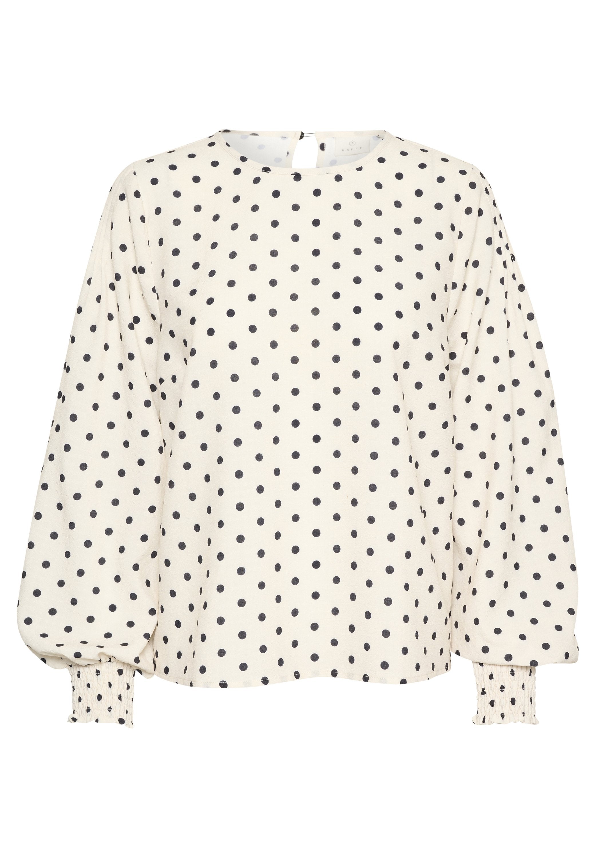 Cremfarbene Bluse mit schwarzen Punkten, runder Ausschnitt, Schlüsselverschluss hinten und Puffärmeln mit gerafften Manschetten. Weicher Baumwollmischstoff.
