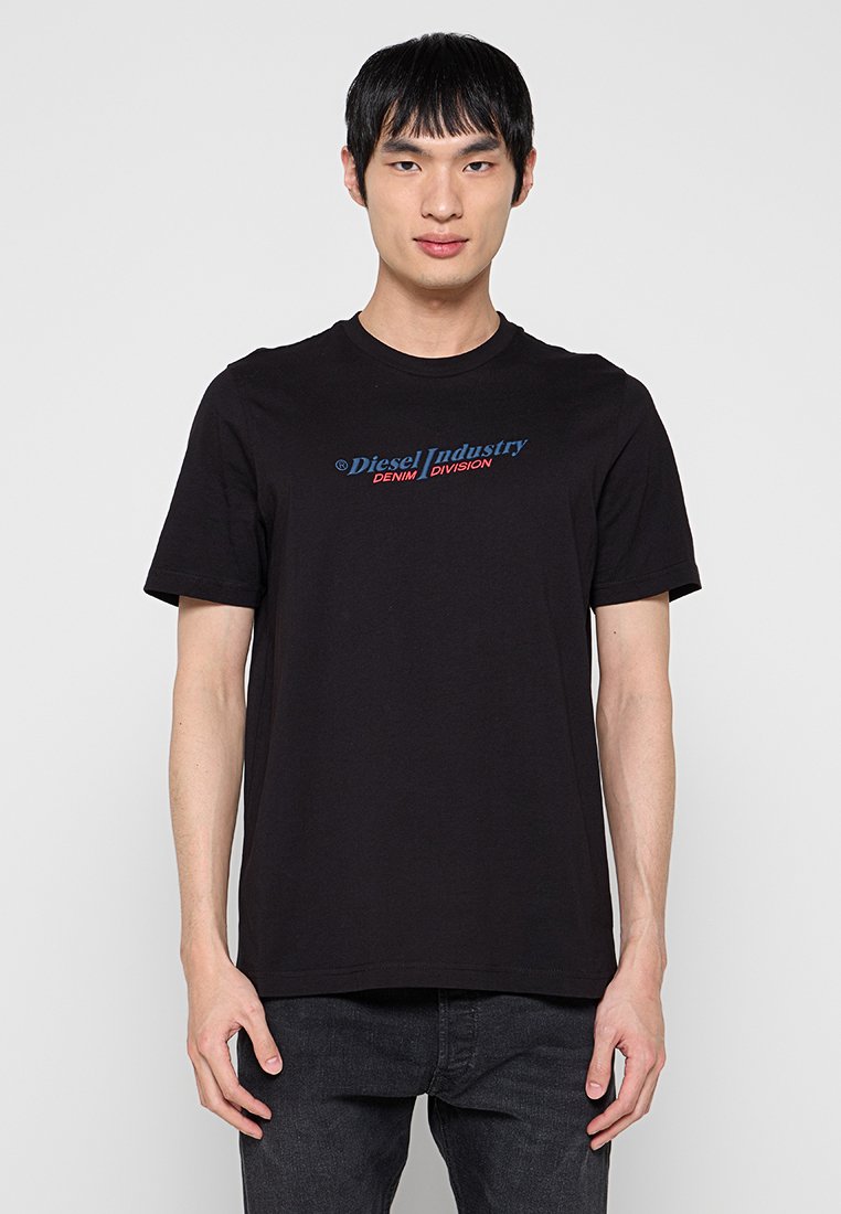 Schwarzes Baumwoll-T-Shirt mit einem grafischen Logo in Blau und Rot auf der Brust mit der Aufschrift "Diesel Industry DENIM DIVISION". Kurze Ärmel, Rundhalsausschnitt.