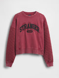 Rotes, kurz geschnittenes Sweatshirt mit der Aufschrift "STRANGER THINGS" in schwarzer Schrift. Verfügt über eine gesteppt wirkende Textur an den Ärmeln sowie gerippte Bündchen und einen gerippten Ausschnitt.