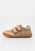 Beiger und rosa Wildledersneaker für Kinder mit zwei Klettverschlüssen und flexibler brauner Gummisohle, seitlich auf weißem Hintergrund gezeigt.