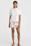 Weißes Baumwoll-T-Shirt mit einem kleinen pinken Halbkreis-Design, kombiniert mit pinken und blauen Batikshorts. Glatte Textur, lässige Passform.