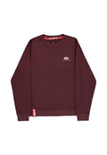 Dunkelrotes Sweatshirt mit Rundhalsausschnitt und langen Ärmeln, kleines weißes Alpha Industries-Logo auf der Brust und rotes Stoffetikett nahe dem unteren Saum.