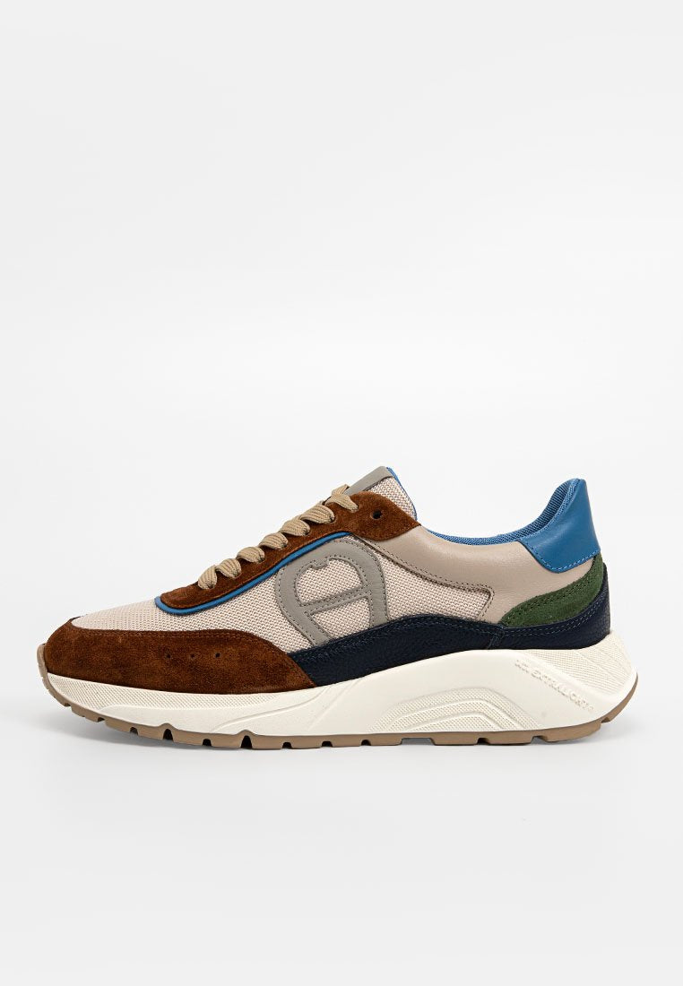 Beige Sneaker mit braunem Wildleder, navy und grünen Akzenten, blauer Ferseneinsatz, beigen Schnürsenkeln, Mesh-Gewebe und dicker weißer Sohle.