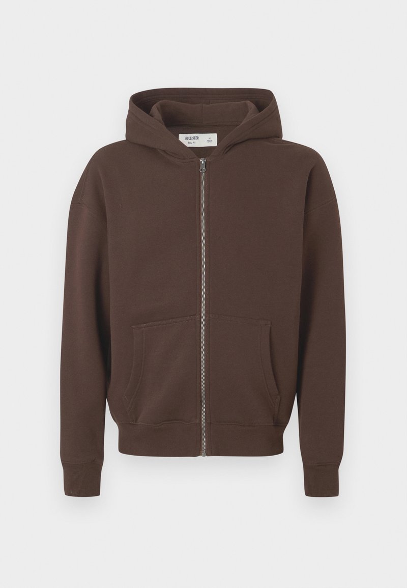 Braune Zip-Hoodie aus weichem Stoff. Sie hat eine Kängurutasche, gerippte Bündchen und eine Kapuze mit Kordelzug für eine verstellbare Passform.