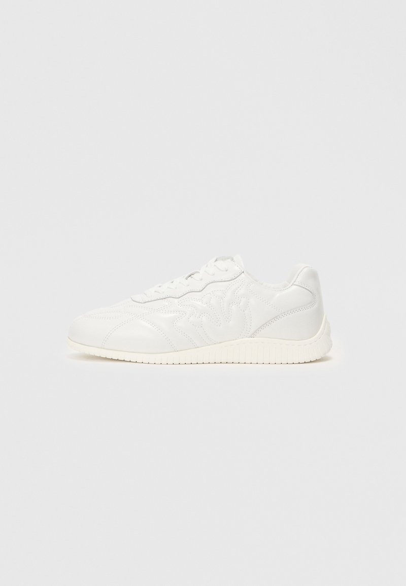 Weißer Sneaker mit Obermaterial aus glattem Leder und strukturiertem Seitenmuster. Schnürdesign mit runder Zehenkappe und weißer Gummisohle. Minimalistischer Stil.