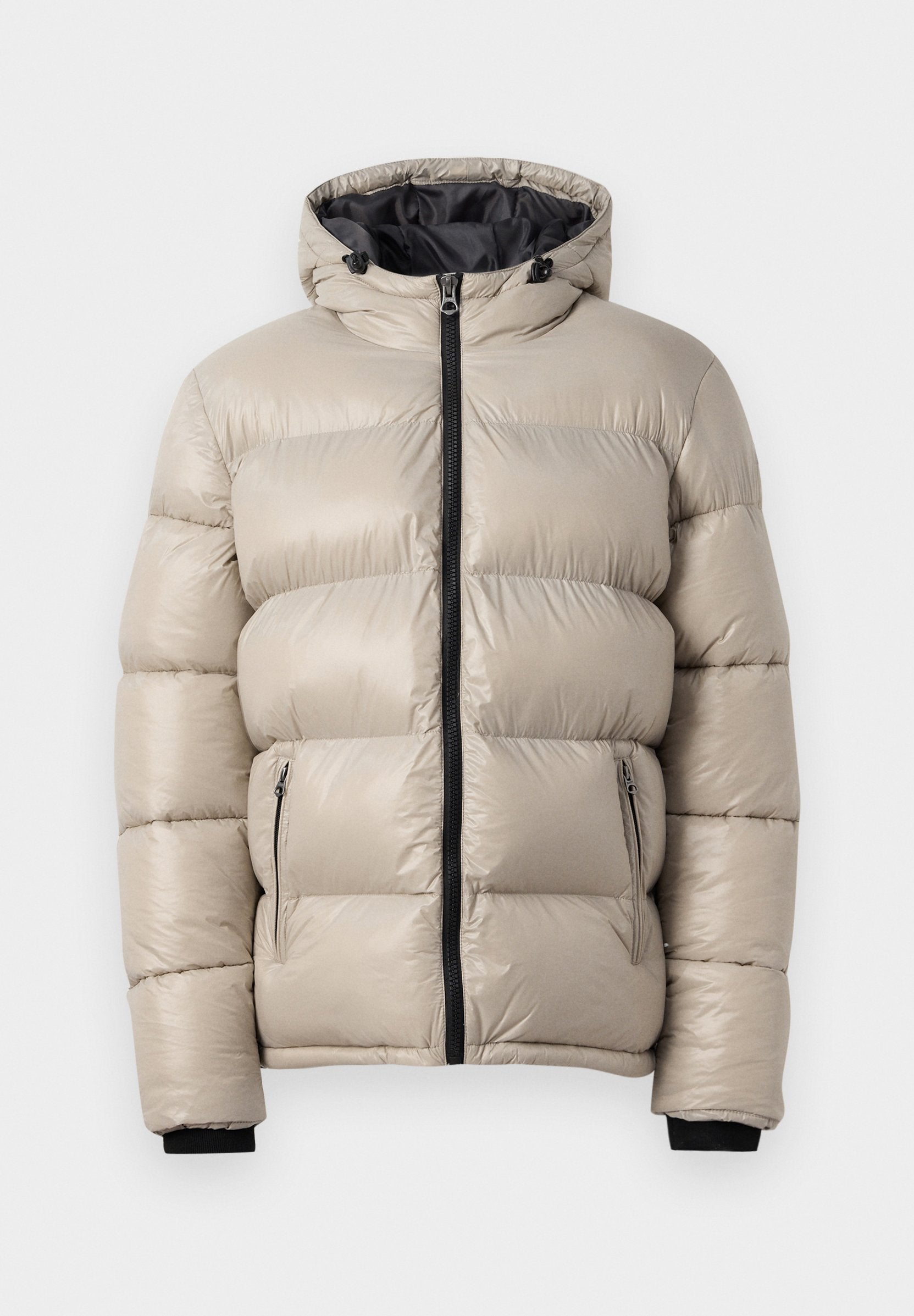 Puffermantel in Hellbeige, mit Kapuze, einem Reißverschluss vorne und zwei seitlichen Reißverschlusstaschen. Texturiertes, gesteppte Design mit elastischen Bündchen.