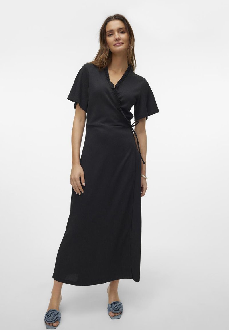 Schwarzes Wickelkleid mit kurzen, flatternden Ärmeln, Rüschendetails entlang des Ausschnitts und einem seitlichen Bindeband zur Anpassung. Glatte Stofftextur.
