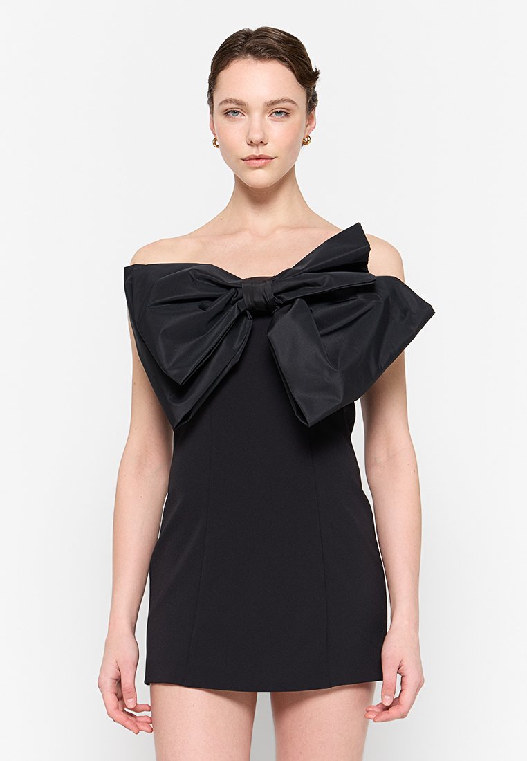 Schwarzes, schulterfreies Minikleid mit einer übergroßen Schleife auf der Brust, aus glattem Stoff mit einer eleganten, figurbetonten Silhouette.
