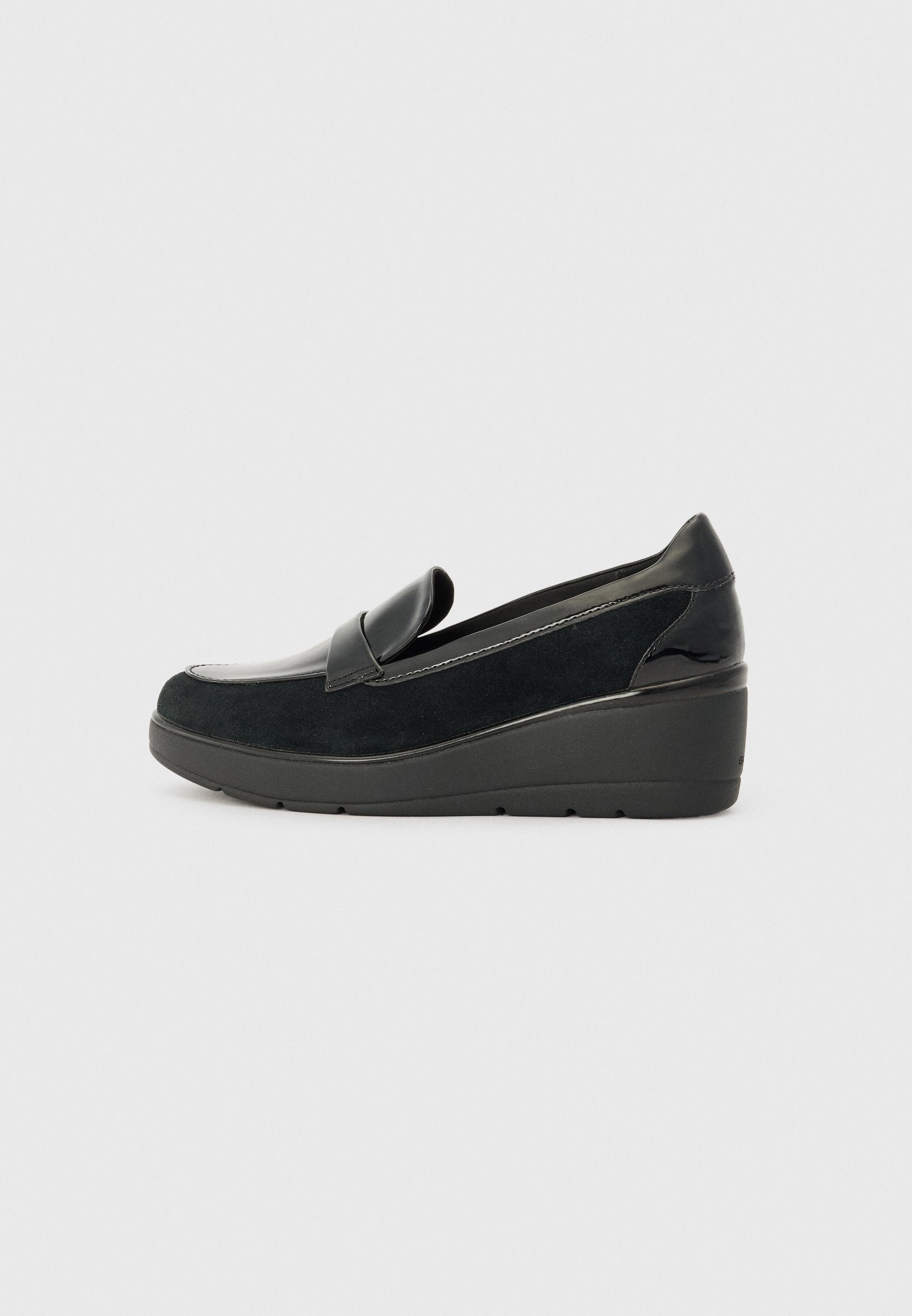 Schwarzer Wildleder-Slipper mit glänzendem schwarzen Lacklederakzent, Keilsohle und einem glatten, abgerundeten Zehendesign.