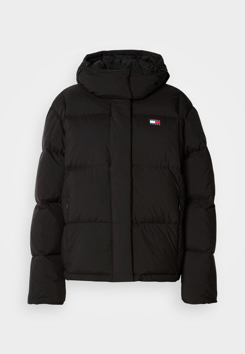 Schwarze Steppjacke mit Kapuze, ausgestattet mit einem gequilteten Design, seitlichen Taschen und einem kleinen Logo-Patch auf der Brust. Glatte, matte Textur.