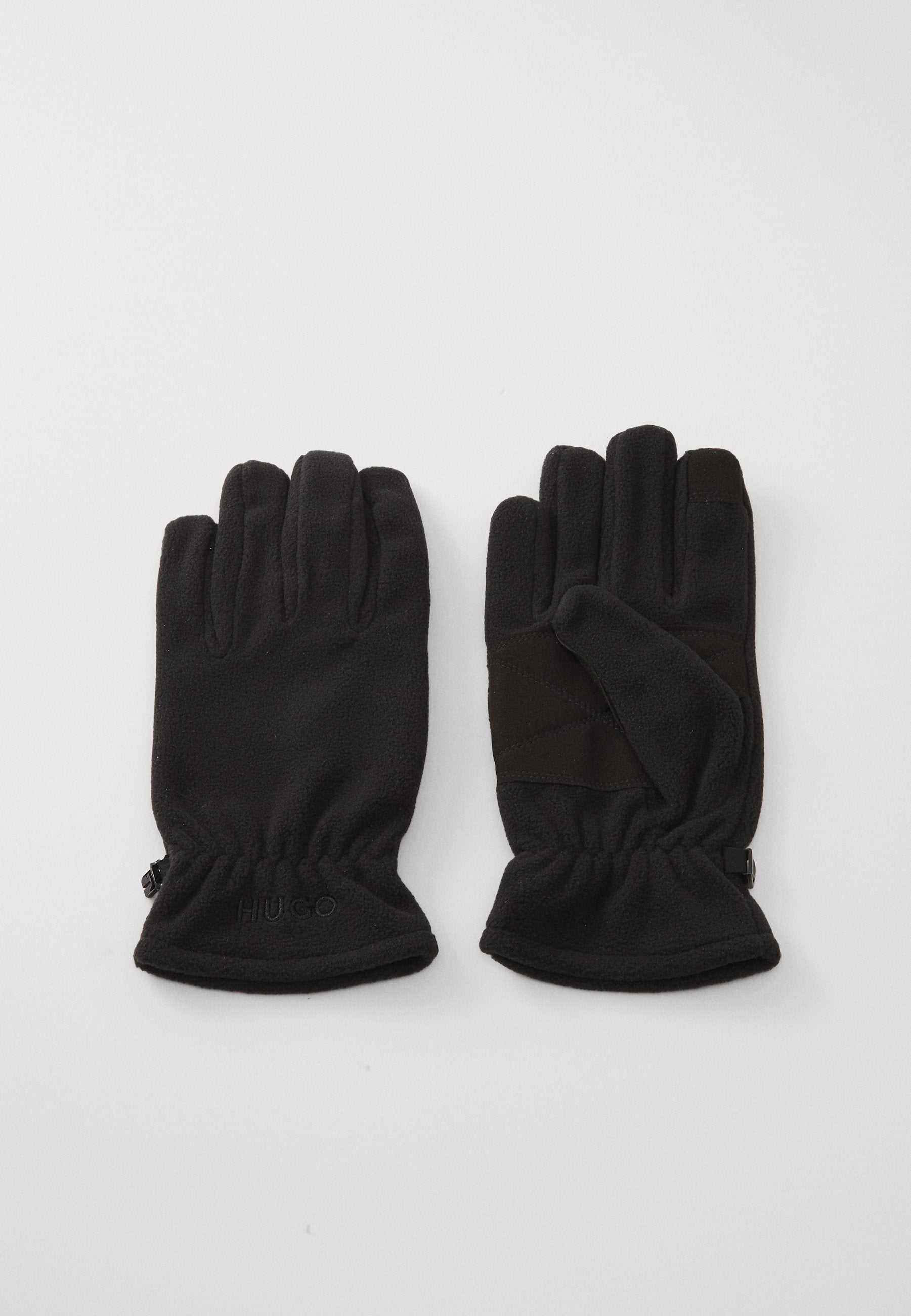 Schwarze Fleece-Handschuhe mit strukturiertem Finish, ausgestattet mit elastischen Bündchen und einem dezenten, am Handgelenk geprägten Logo. Auffälliges Fingendesign für hohe Fingerfertigkeit.