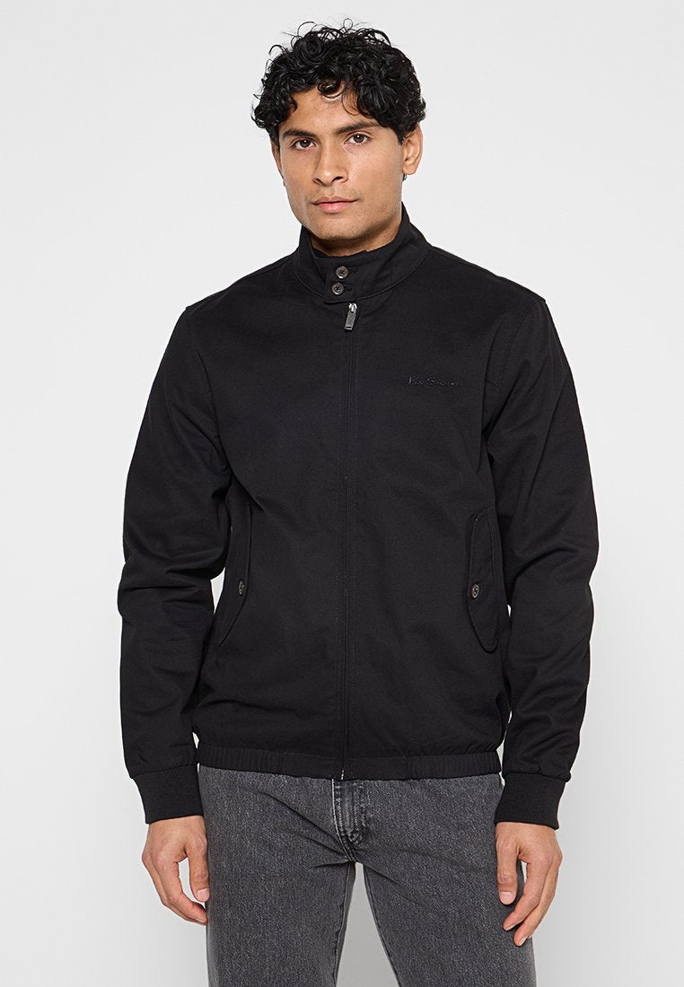 Schwarze Jacke mit strukturiertem Kragen, Reißverschluss und Seitentaschen. Verfügt über eine glatte Textur und gerippte Bündchen für zusätzlichen Stil.