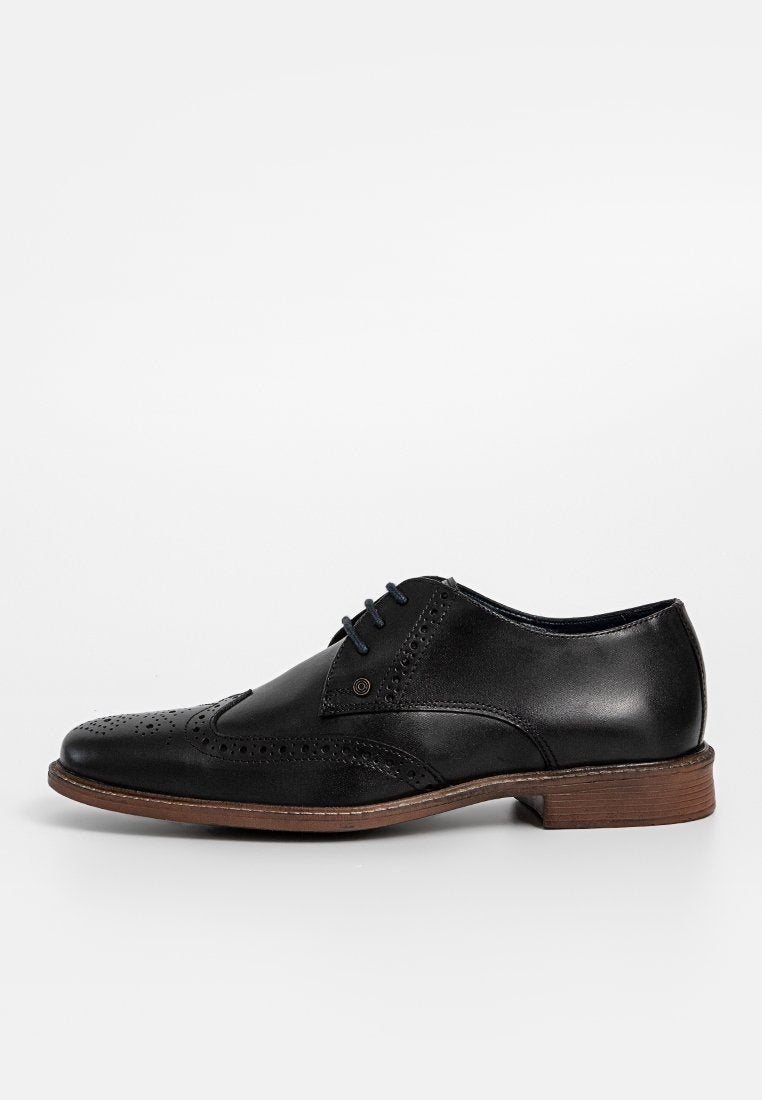 Schwarzer Lederschuh mit Brogue-Details, blauen Schnürsenkeln und einer braunen Ledersohle. Verfügt über eine gerundete Spitze und einen polierten Finish.