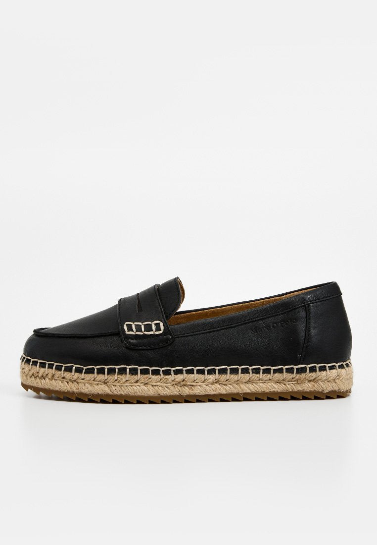 Schwarzer Lederloafer mit geflochtener Jutsohle und Gummisohle, mit einem Riemen mit dekorativen Nähten auf weißem Hintergrund.