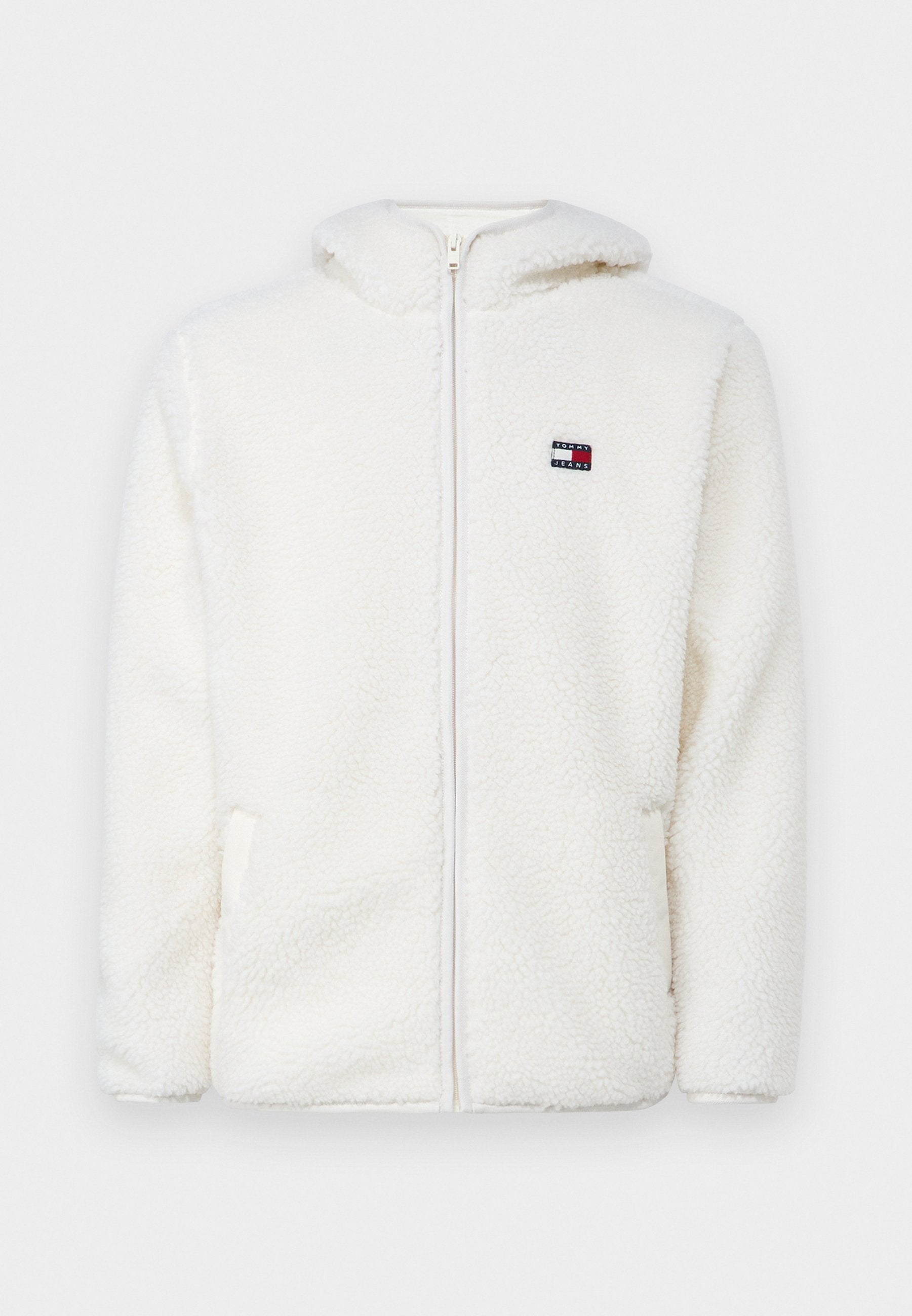 Weißer Fleece-Zip-Hoodie mit weicher Textur, ausgestattet mit einer Kapuze und seitlichen Taschen. Kleines Logo auf der linken Brust. Glatte Reißverschlussöffnung.