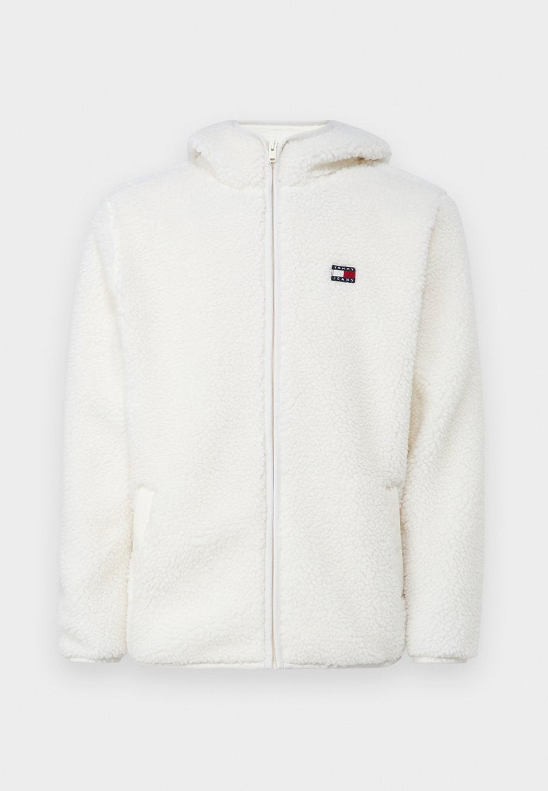 Weißer Fleece-Zip-Hoodie mit weicher Textur, ausgestattet mit einer Kapuze und seitlichen Taschen. Kleines Logo auf der linken Brust. Glatte Reißverschlussöffnung.