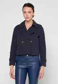 Kürzere marineblaue Jacke aus Baumwollmix, mit einem doppelt geknöpften Design, großen Revers und goldenen Knöpfen, kombiniert mit hochgeschnittenen blauen Hosen.