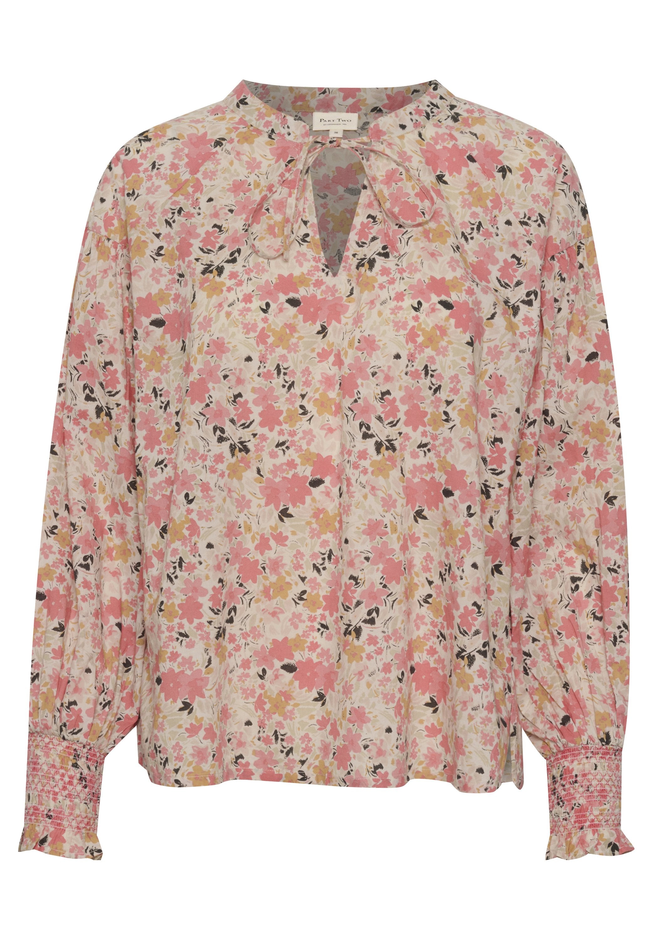 Bluse mit langen Ärmeln im Blumenmuster, mit einem Schlüsselloch-Ausschnitt, rosa und gelben Blumen auf einem cremefarbenen Hintergrund und gesmockten Manschetten.