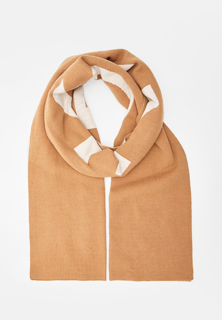Hellbrauner Strickschal mit weißen geometrischen Akzenten, zu einer Schlaufe gefaltet, mit gerade hängenden Enden.