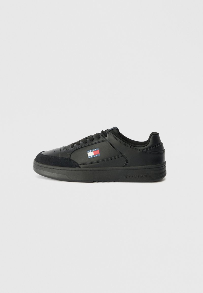 Schwarzer Sportschuh aus glattem Leder mit Wildlederakzenten, runder Zehenform, Schnürung an der Vorderseite und einem kleinen Logopatch an der Seite.