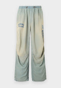 Hellblaue und beige Jeans mit weitem Bein, elastischem Bund, Kordelzug und verblassten "Diesel"-Logos auf dem oberen linken und rechten Bein.