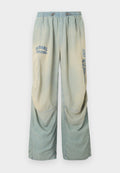 Hellblaue und beige Jeans mit weitem Bein, elastischem Bund, Kordelzug und verblassten "Diesel"-Logos auf dem oberen linken und rechten Bein.