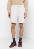 Graue Baumwoll-Sweatshorts mit elastischem Bund und Kordelzug. Verfügt über seitliche Taschen und eine lässige Passform, kombiniert mit bordeauxfarbenen Sneakers.