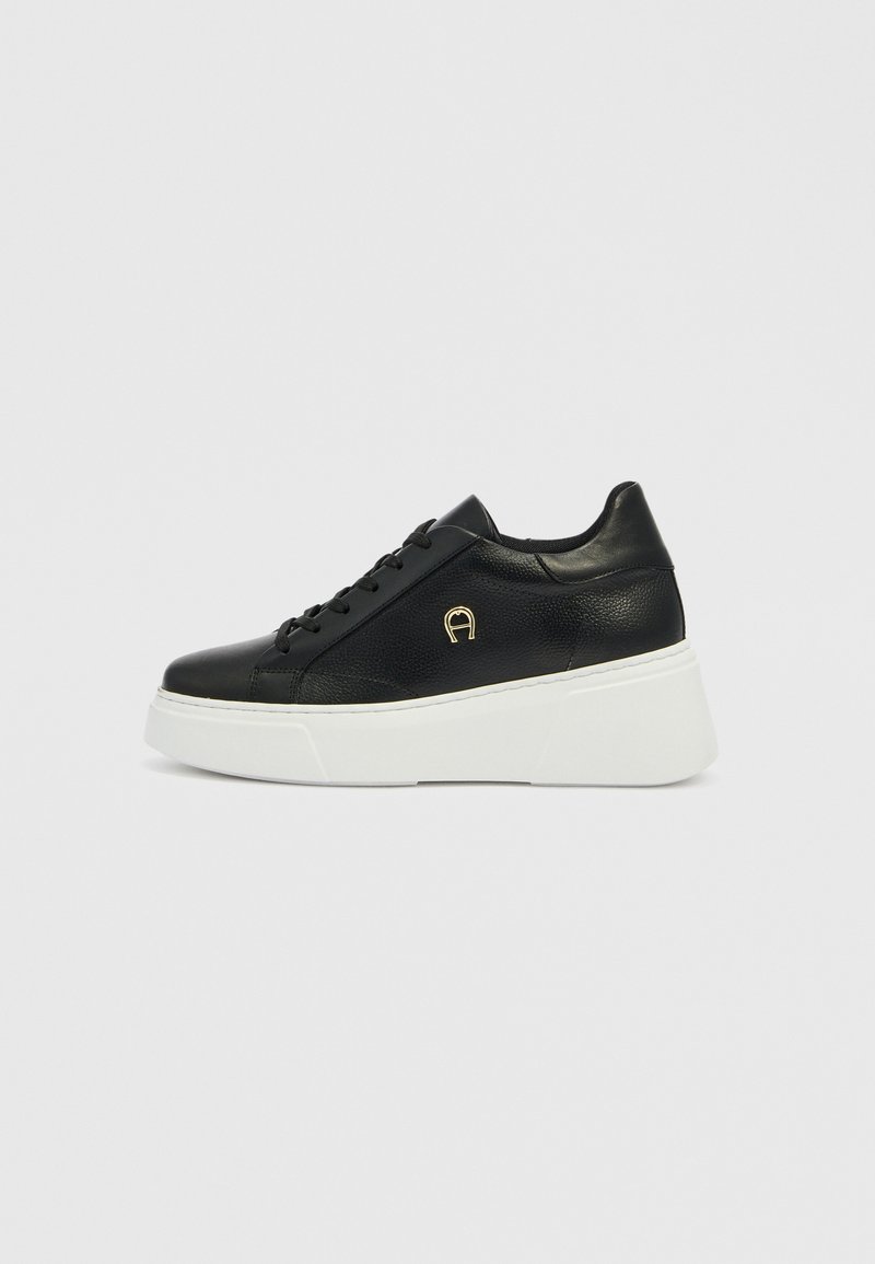 Schwarzer Ledersneaker mit strukturierter Oberfläche, ausgestattet mit weißer Plateausohle, rundem Zehenbereich, schwarzen Schnürsenkeln und einem kleinen goldenen Logo-Akzent.