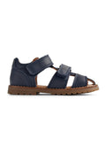 Marineblaue Ledersandalen mit Klettverschlüssen, offener Zehenpartie und brauner Gummisohle. Mit genähten Details und flachem Profil.
