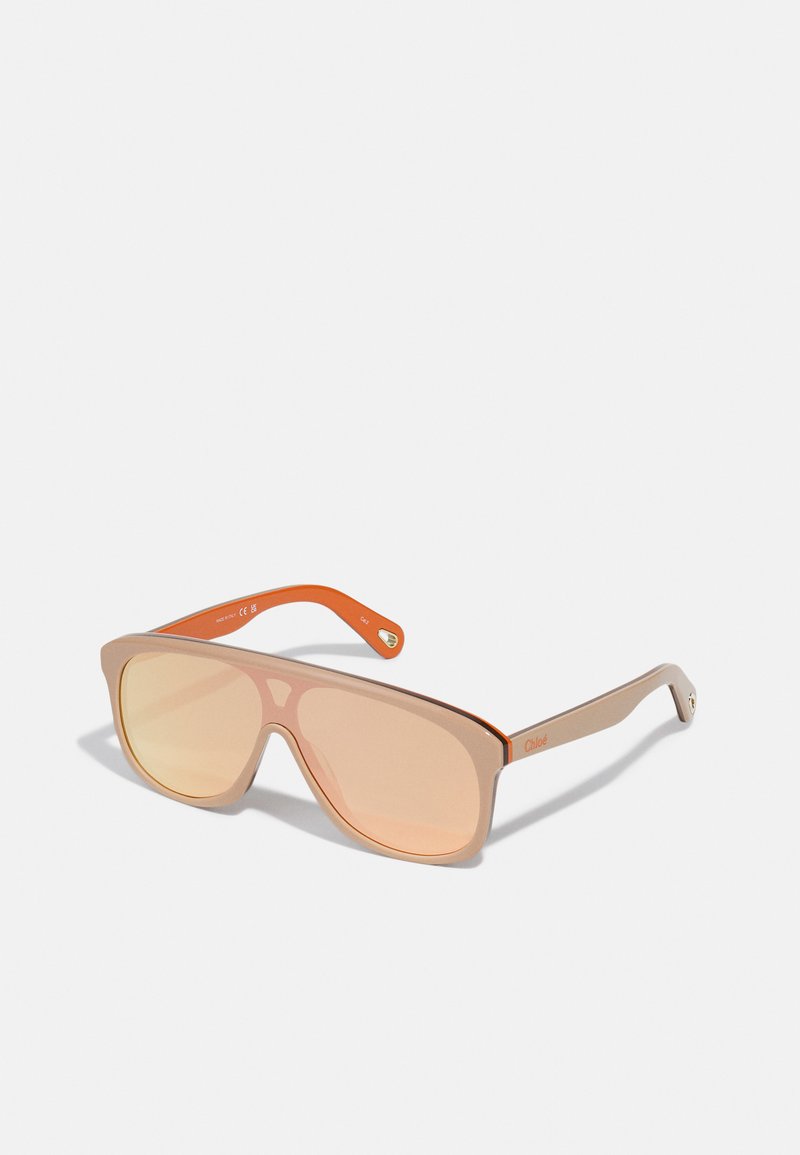 Sonnenbrille mit einem hellbraunen Rahmen, orangefarbenen Bügeln und roséfarbigen Gläsern. Flaches Design mit minimalistischer, kantiger Form und subtiler Markenkennzeichnung.