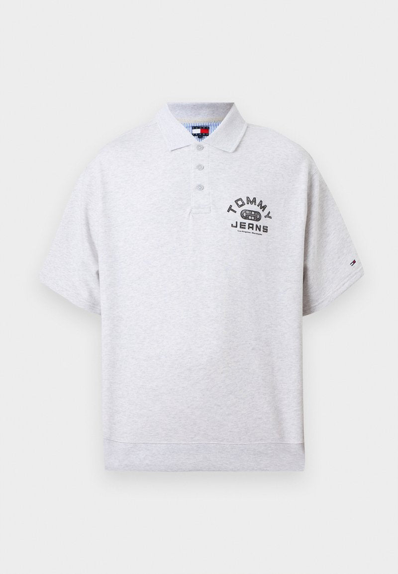 Hellgraues Polohemd mit kurzen Ärmeln, Kragen und drei Knöpfen, mit "Tommy Jeans"-Schriftzug und Logo auf der Brust sowie kleinem Logo am Ärmel.